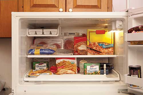 Frozen meals and foods inside an open freezer
